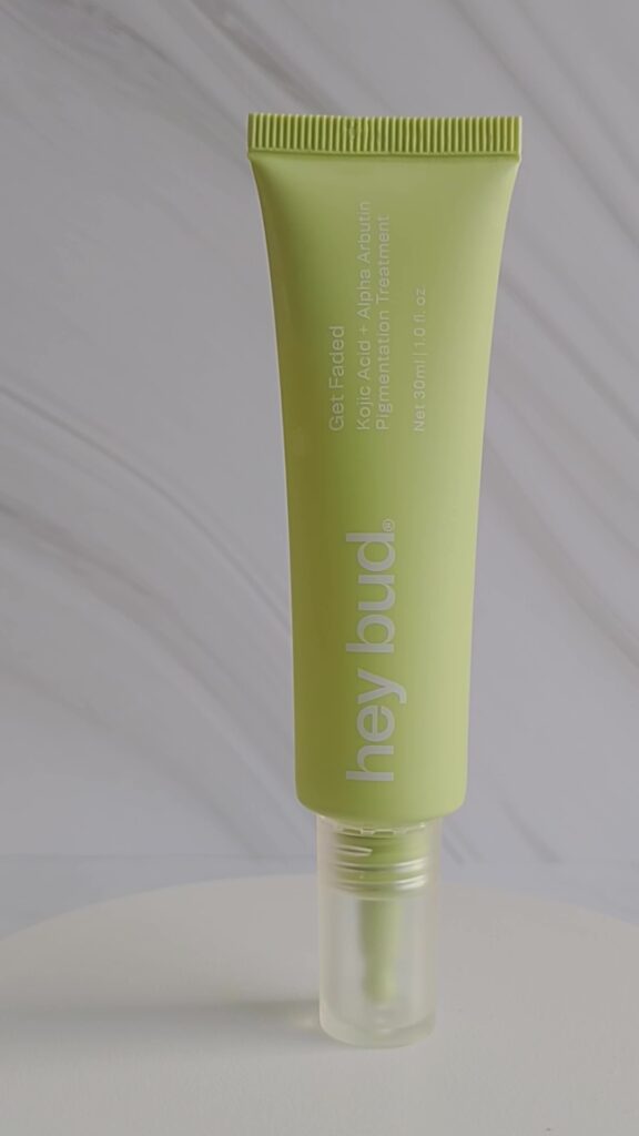 Slim lime-green tube of pigmentation treatment labeled 'Get Faded' with Kojic Acid + Alpha Arbutin, standing on a white surface with a clear cap visible at the bottom.